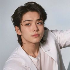 the young man is wearing a white shirt and posing for a photo with his hand on his head