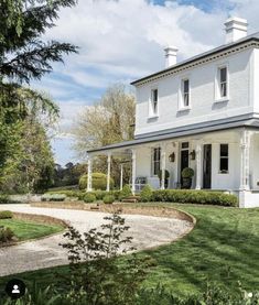 a large white house sitting on top of a lush green field