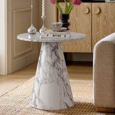 a marble table with flowers on it in a living room