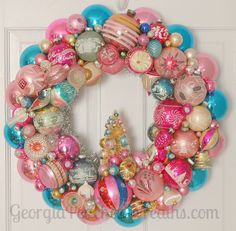 a wreath with ornaments hanging on the front door