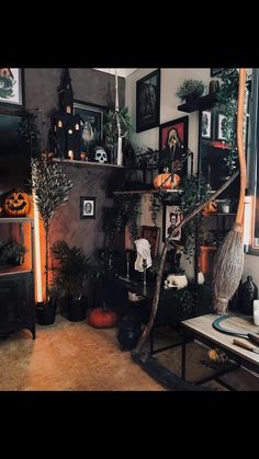 a living room filled with lots of plants and halloween decorations on the wall next to a fire place