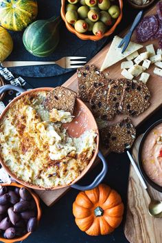 an assortment of food on a cutting board with utensils and other foods around it