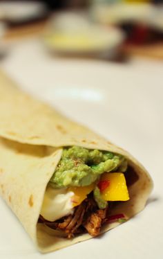 a tortilla filled with meat and guacamole