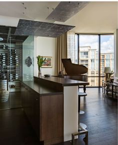 a living room filled with furniture and a piano in front of a large glass window