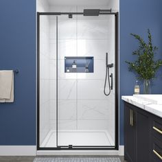 a bathroom with blue walls and white tile on the floor, shower door is open