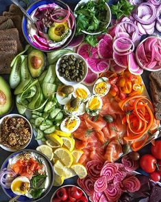 a table filled with different types of vegetables and meats on top of each other