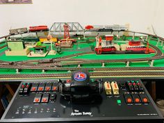 a toy train set on top of a table next to a remote control controller and other accessories