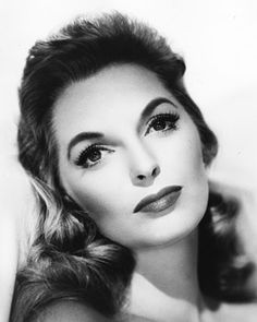 black and white photograph of a woman with long hair wearing a strapless dress, looking off to the side