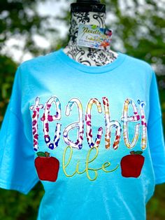 a t - shirt with the words teach life painted on it and two strawberries