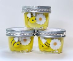 four jars with bees and daisies painted on them