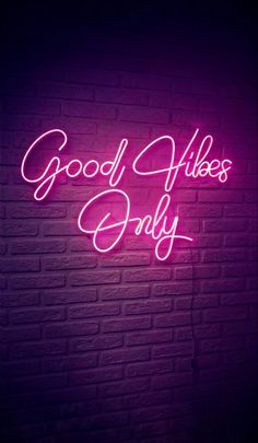 a pink neon sign that says good vibes only on the side of a brick wall