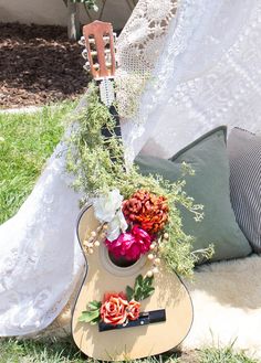 a guitar with flowers on it sitting in the grass