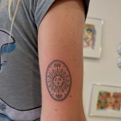 a woman with a sun tattoo on her arm