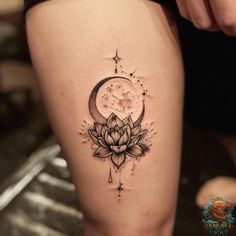 a woman's thigh with a lotus and moon tattoo on the side of her leg