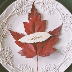 a white plate with a red maple leaf and the name william written in wood on it