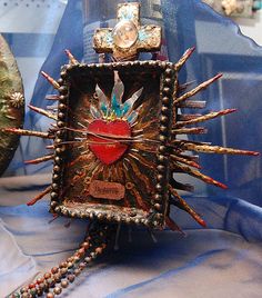 an elaborately decorated box on display with beads and other items in it's holder