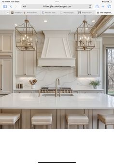 an image of a kitchen with white cabinets and marble counter tops in front of a window