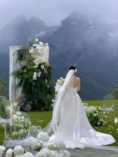 a woman in a wedding dress standing next to flowers