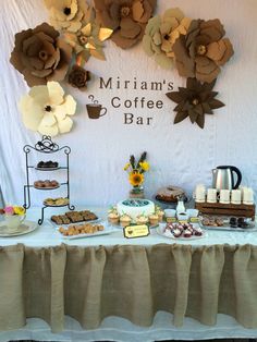 a table topped with lots of desserts next to a sign that says, mmmm's coffee bar