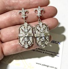 "A pair of Art Deco wedding bridal earrings with Victorian fleur de lis sterling silver posts and Gatsby 1920s vintage style inspired geometric dangles. These elegant lightweight earrings are made of sparkly clear cubic zirconia with posts. Earrings are about 1 5/8\" (4.2cm) with posts. View matching pieces and similar designs at https://etsy.me/2Mu6wjC and https://etsy.me/2FqTa3I Matching brooch pin at https://etsy.me/2Wk6HzE See all geometric designs at https://etsy.me/2eKf6s8 View all earring Gatsby Earrings, Regency Wedding, 1920s Vintage, Deco Wedding, Earrings Geometric, Back Jewelry, Wedding Jewelry Earrings, Zirconia Earrings, Lightweight Earrings