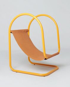 a yellow chair with a curved seat on it's back and an orange metal frame