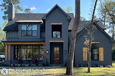 a large gray house with lots of windows and wood trimmings on the front