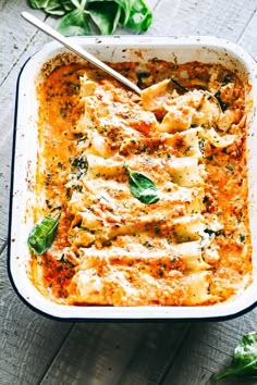 a casserole dish with spinach and cheese in it on a wooden table