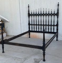 an old iron bed frame is shown in front of a white wall and some boxes