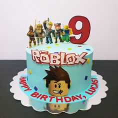 a birthday cake with an image of roblox on the top and candles in the middle