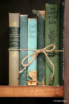 several old books tied together in a book shelf with twine on the top and bottom