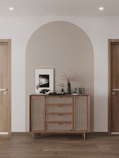 an empty room with two doors and a sideboard in the center, next to a vase on top of a wooden cabinet