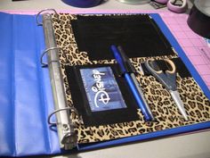 a binder with scissors and other items on it