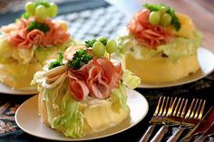 three plates with food on them sitting on a table next to forks and silverware