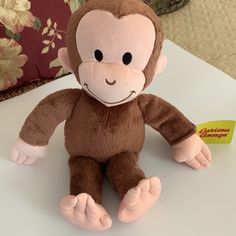 a stuffed monkey sitting on top of a white table