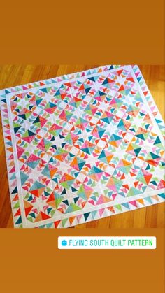 an image of a colorful quilt on the floor with text reading flying south quilt pattern