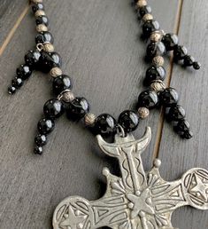 This beautiful, one-of-a-kind pewter ornate cross necklace will inspire all your moonlit nights. Handmade with black agate and glass beads. Measures 18 inches long and has a 2 inch extender chain. product details silver tone metals; Cross is soft pewter. 18 inches long with 2 inch extender black agate and glass beads VISIT MY SHOPS HERE * http://www.etsy.com/shop/HappyCatHouse * http://www.Etsy.com/shop/AnEnchantingCreature CONNECT * http://www.facebook.com/EnchantingCreature * https://www.insta Black Adjustable Crucifix Necklace, Adjustable Black Crucifix Necklace, Silver Cross Jewelry With Black Beads, Adjustable Cross Necklace With Black Beads, Adjustable Black Beads Cross Necklace, Gothic Cross Necklace For Festivals, Gothic Black Metal Cross Necklace, Gothic Black Cross Pendant Necklace, Adjustable Gothic Cross Pendant Jewelry