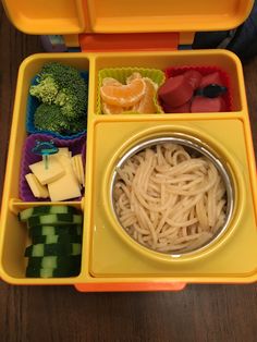 a yellow lunch box filled with lots of food