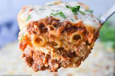 a fork full of lasagna with meat and cheese