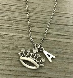 a silver necklace with the word love on it and an initial charm attached to it