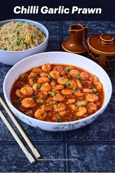 a bowl of chili garlic prawn next to two bowls of rice and chopsticks