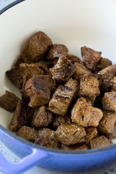 a bowl filled with meat sitting on top of a table