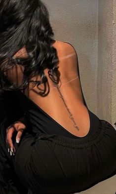 the back of a woman's body with writing on her lower back and right arm