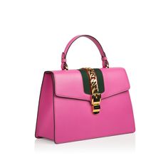 Nothing says Gucci more than the iconic Gucci Sylvie Top Handle Bag. For the women looking to make a statement to the outside world, you simply cannot go wrong with the beautiful handheld bag. The eye-catching contrast between the hot pink leather and the classic Gucci stripes down the middle is bound to make you the most stylish woman on the scene, wherever you are. And it doesn’t stop there - the vibrant, gold chain down the middle, adding some more glam to it, makes this handbag one of our stylist’s favourites and a true must-have. SPL Exterior Pink leather Gold toned hardware Green and red nylon Detachable shoulder strap Excellent condition Interior Interior zip and smartphone pockets Microfiber lining with a suede-like finish One lipstick compartment Sold with dustbag and box Excellen Gucci Sylvie Bag, Gucci Sylvie, Mode Rose, Gucci Top, Gucci Purse, Gucci Purses, Fotografi Vintage, Large Handbag, Genuine Leather Purse