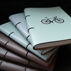 a stack of notebooks sitting on top of each other with a bike drawn on them