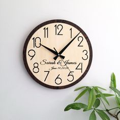 a clock on the wall next to a potted plant