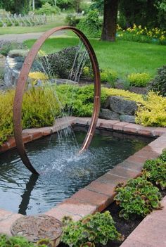 a water feature in a garden with rocks and plants