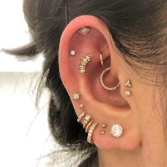 a woman wearing ear piercings with different types of jewelry on her ears and behind the ear