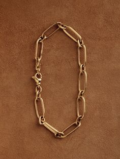 In our quest for the perfect chain—one that could be handcrafted and worn daily, with timeless elegance—we designed and made the Long & Short Chain. Featuring a traditional pattern of elongated, paperclip-style links joined by smaller ovals, this chain lays flat against the arm or chest in a seamless arrangement. Each link is carefully shaped, assembled, and fully soldered by hand in our Burlington studio. The chain is secured with a subtly adorned lobster clasp, designed for durability. On the Classic Oval Link Chain Bracelets, Metal Paperclip Chain Bracelet With Oval Links, Elegant Metal Paperclip Bracelet With Oval Links, Formal Chain Link Bracelet With Hook And Links, Classic Oval Link Chain Bracelet For Everyday, Timeless Link Chain Bracelet For Formal Occasions, Classic Link Chain Bracelet For Formal Occasions, Classic Oval Metal Chain Bracelet, Timeless Jewelry With Cable Chain Links