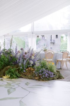 an outdoor dining area with flowers and greenery