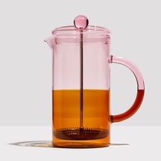 a glass tea pot filled with orange liquid